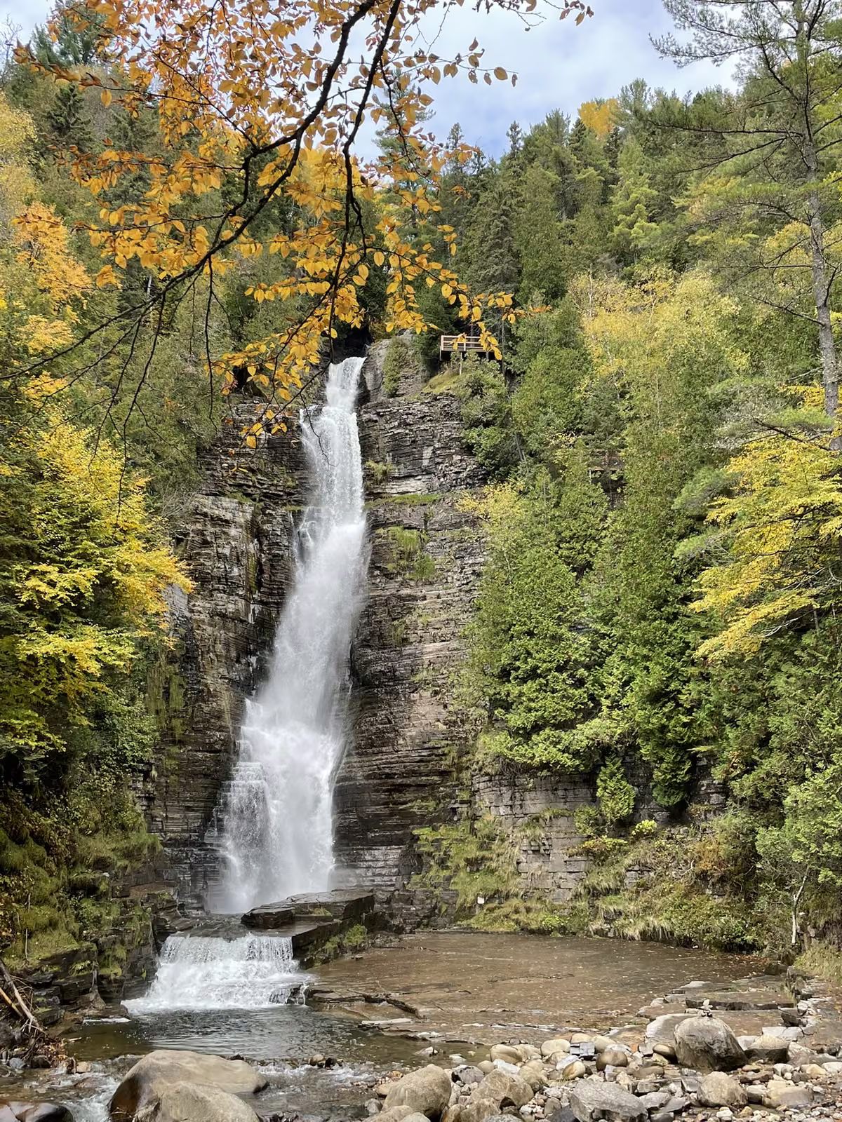 Chute d'eau encadrée de feuillage doré en automne au Québec