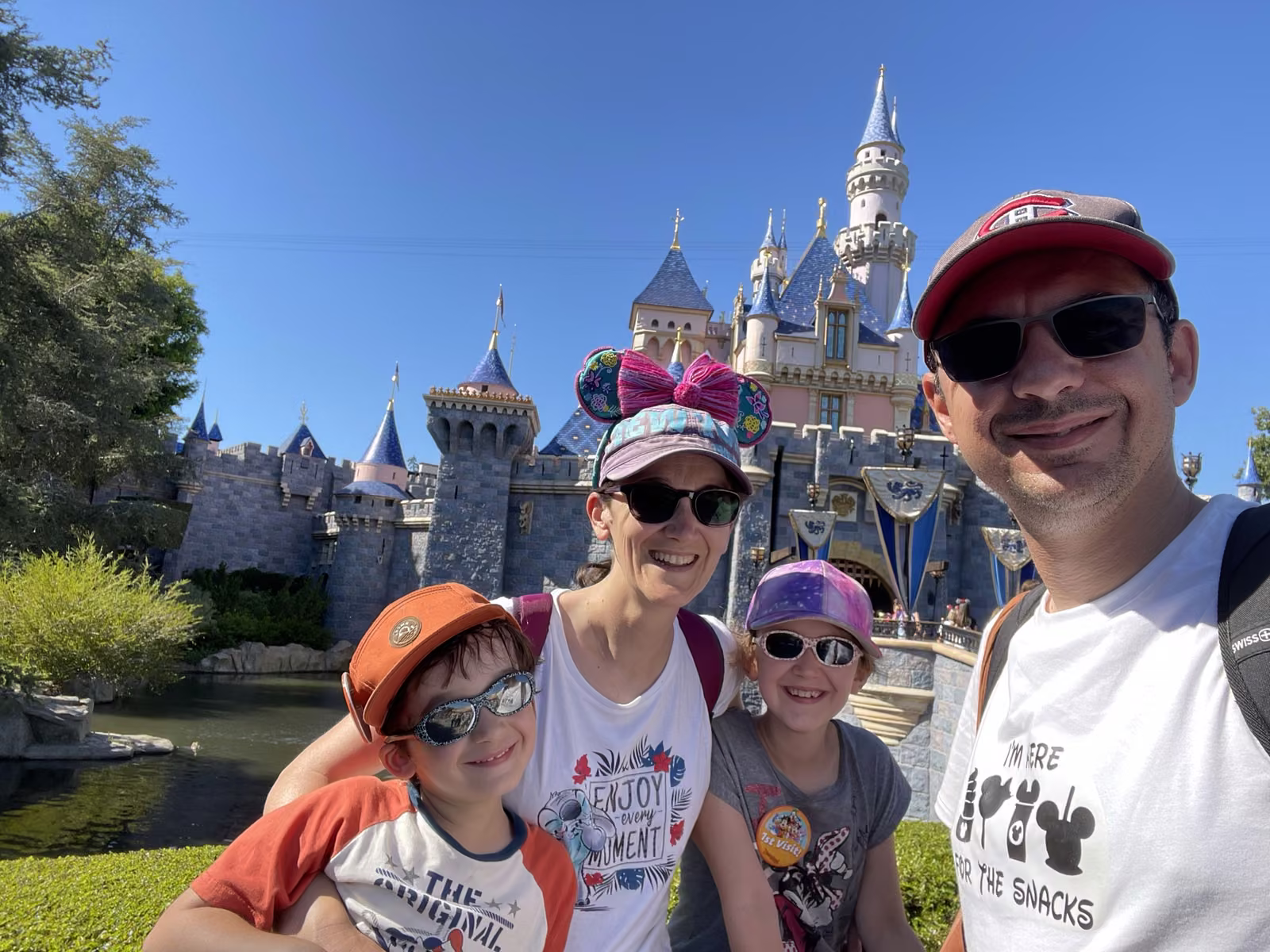 Famille posant devant le château de Disneyland Park en Californie