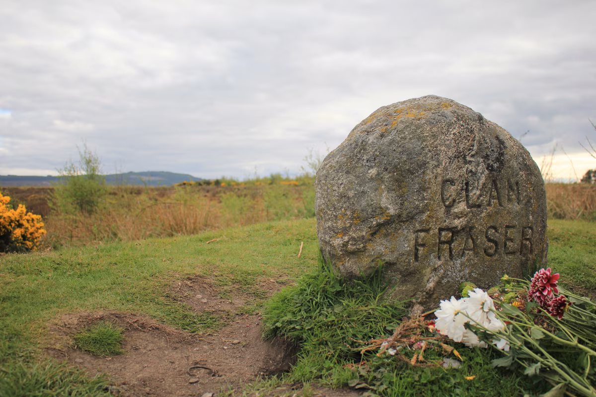 La pierre tombale du Clan Fraser sur le champ de bataille de Culloden, avec des fleurs déposées par les fans