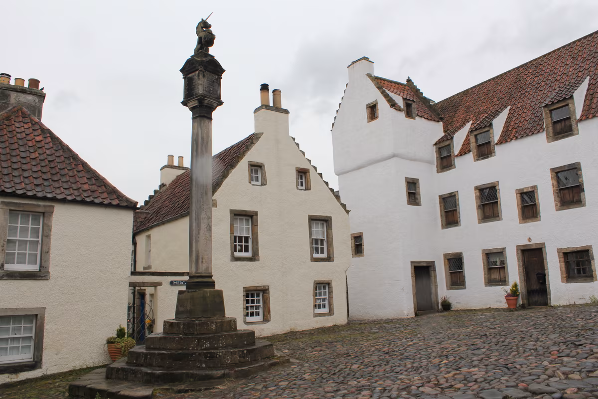 La place du village de Culross avec ses maisons blanches et sa croix de marché, Cranesmuir dans Outlander
