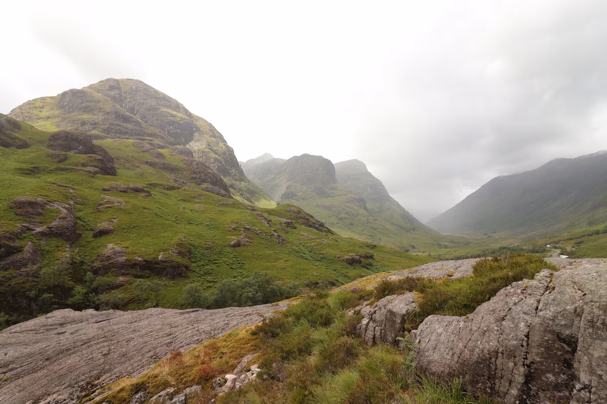 La vallée de Glencoe dans les Highlands, montagnes verdoyantes sous un ciel brumeux
