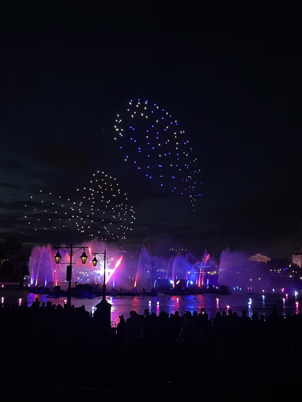 Spectacle nocturne Disney Cascade of Lights avec drones et fontaines au-dessus d'Adventure Bay
